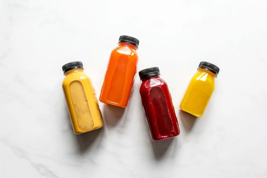 Colorful smoothies in bottles on a white background, ideal for healthy lifestyle concepts.