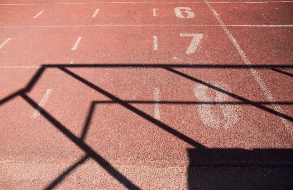 A sunlit athletics track marked with numbers and dynamic shadows, perfect for sports themes.