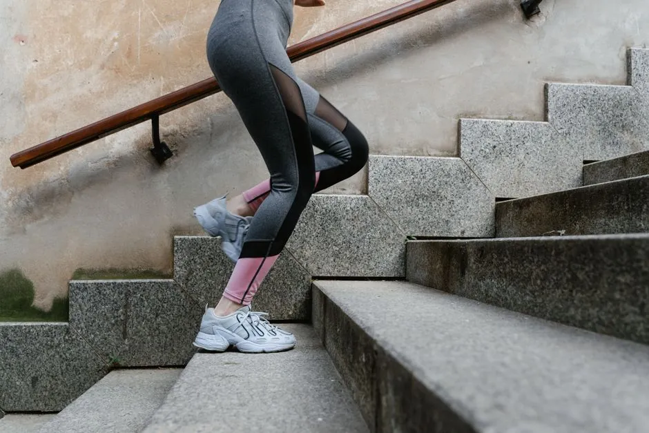 Woman engaging in fitness activity by running up concrete stairs outdoors.