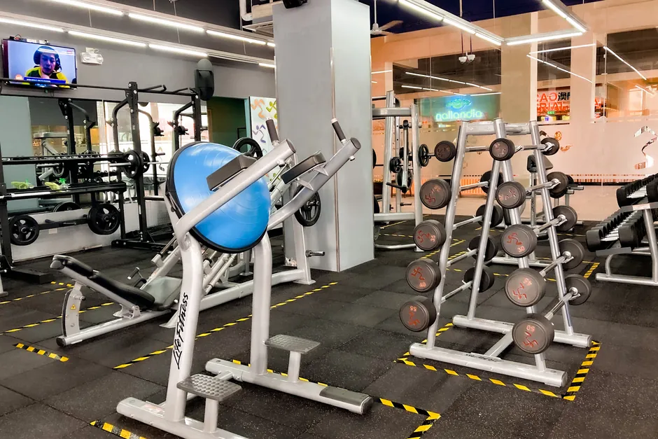 A modern gym featuring exercise equipment, weights, and a fitness center atmosphere.