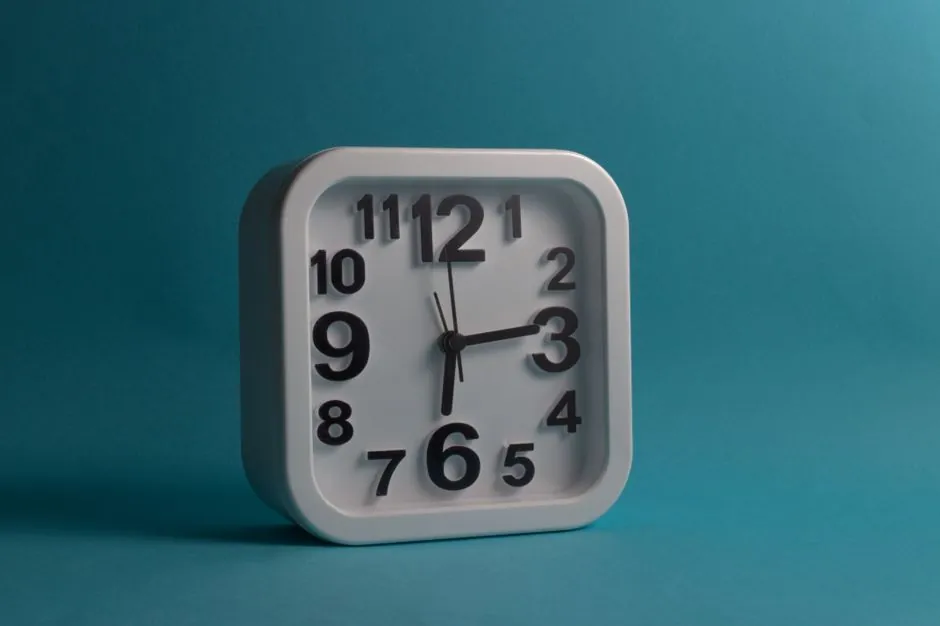 Square white wall clock displaying 10:10 against a blue backdrop, perfect for minimalistic and modern design themes.