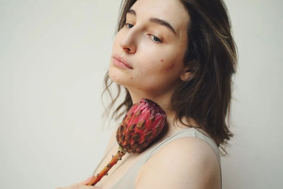 A woman holding a protea flower, highlighting natural beauty and skin texture
