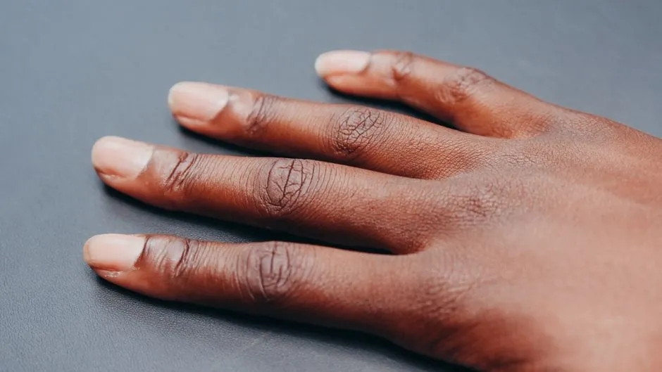 Detailed close-up image of a hand and fingers against a neutral background.