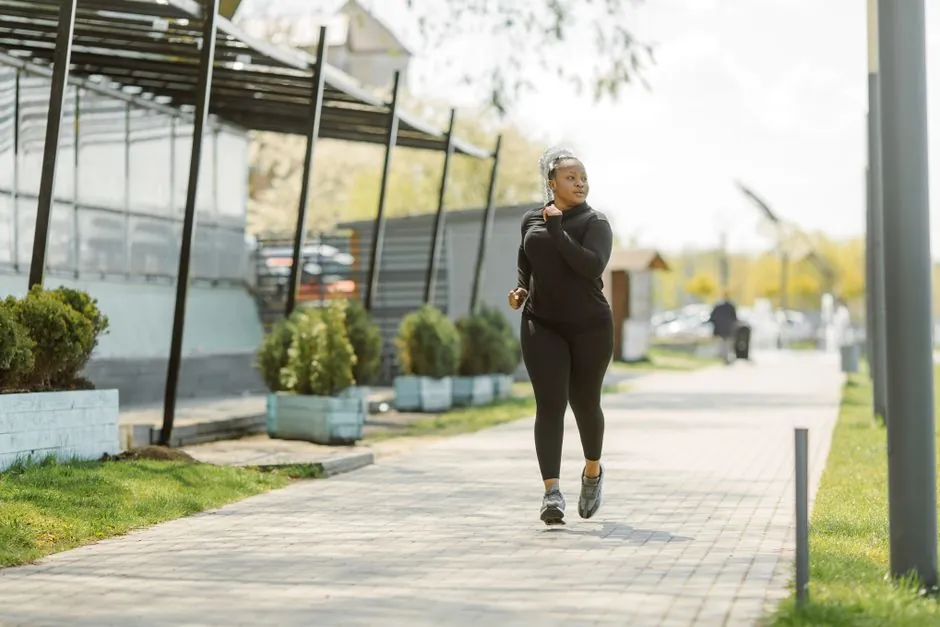 An African American woman jogging on a sunny day, embracing a healthy lifestyle.